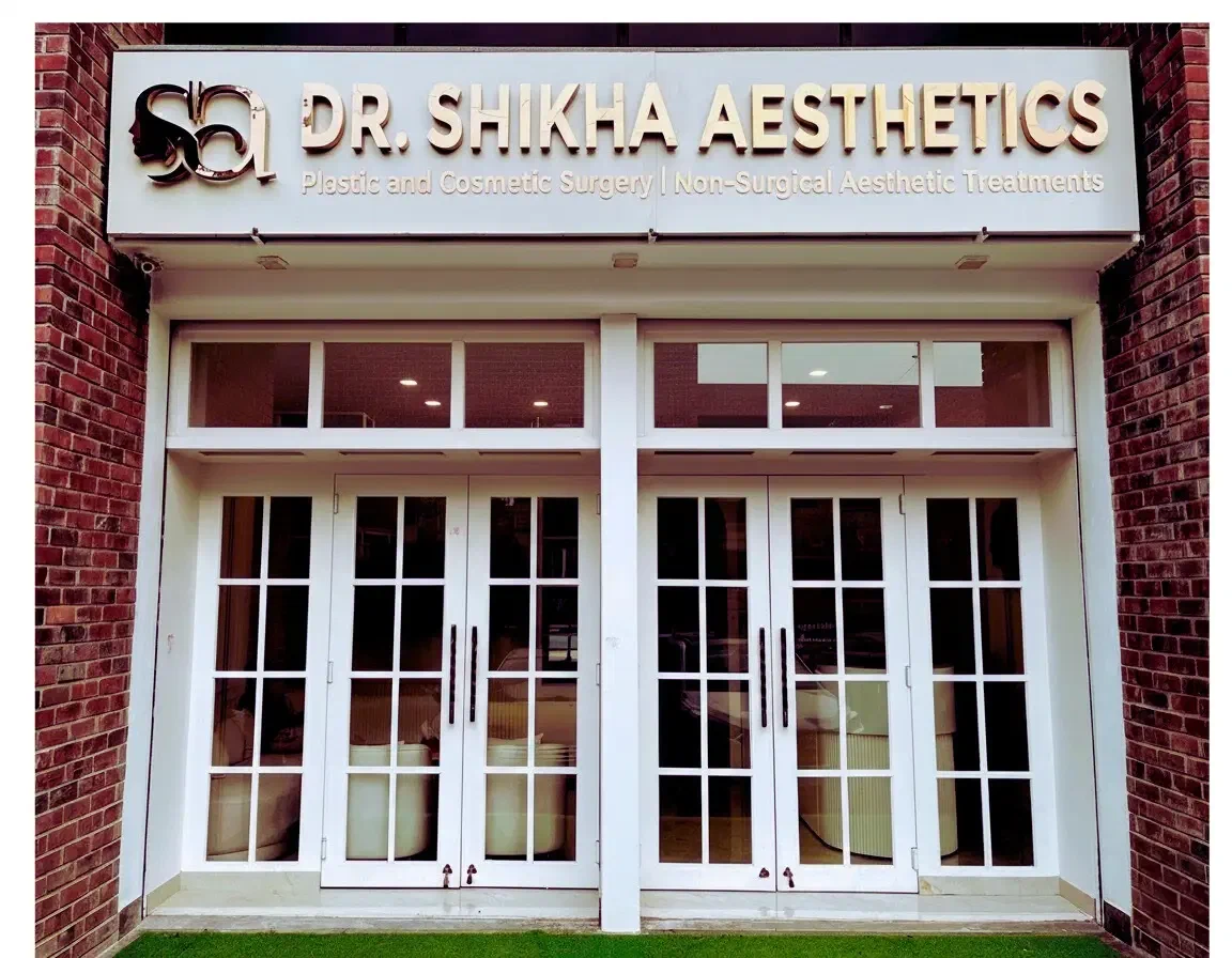 The entrance to Dr. Shikha Aesthetics in Sushant Lok 1, Gurgaon, with its white doors and sign